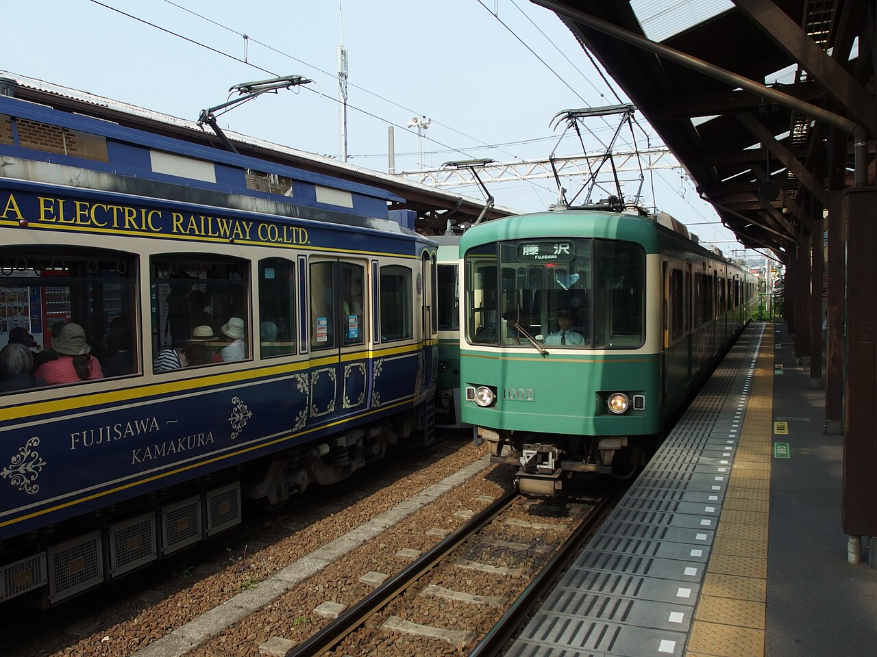 東京発・鎌倉日帰りモデルコース|江ノ電で回る定番8スポット 7 江ノ電の駅で行き違う2本の車両。右は藤沢行きの緑とクリームの電車