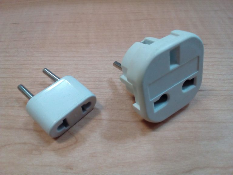 木の机に置かれた2つの変換プラグ。左はCタイプの丸ピン、右はBFタイプの角ピン