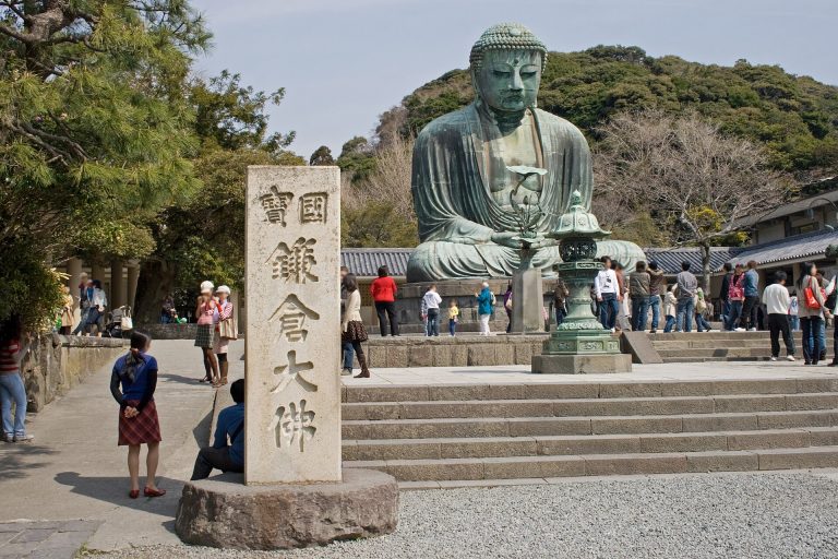 高徳院の境内に座る鎌倉大仏と、手前に立つ「国宝 鎌倉大佛」の石柱