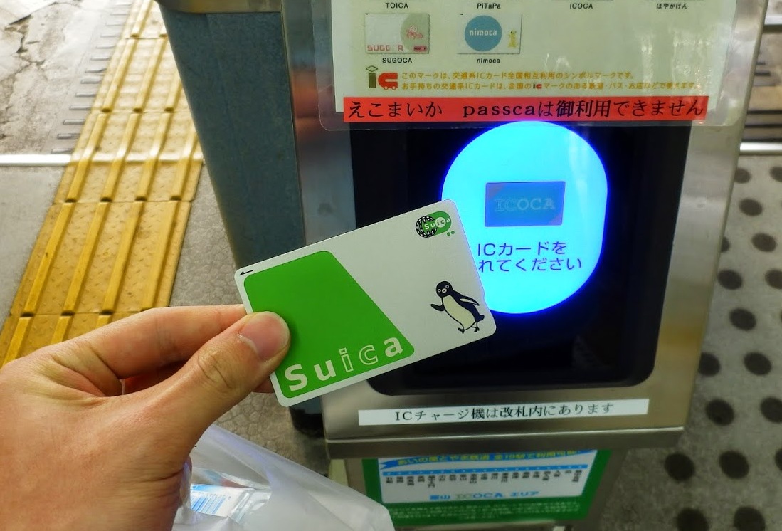 改札のリーダーにSuicaカードをタッチする手元