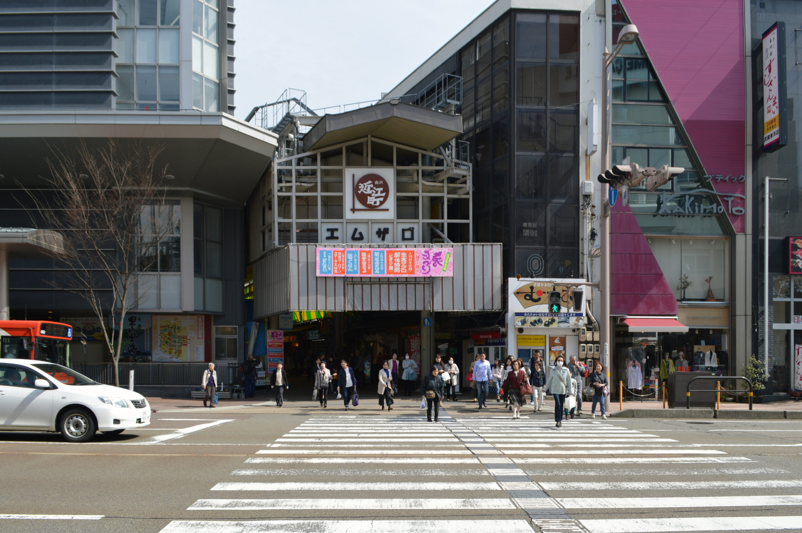 近江町市場のエムザ口の入口と、横断歩道を渡る買い物客