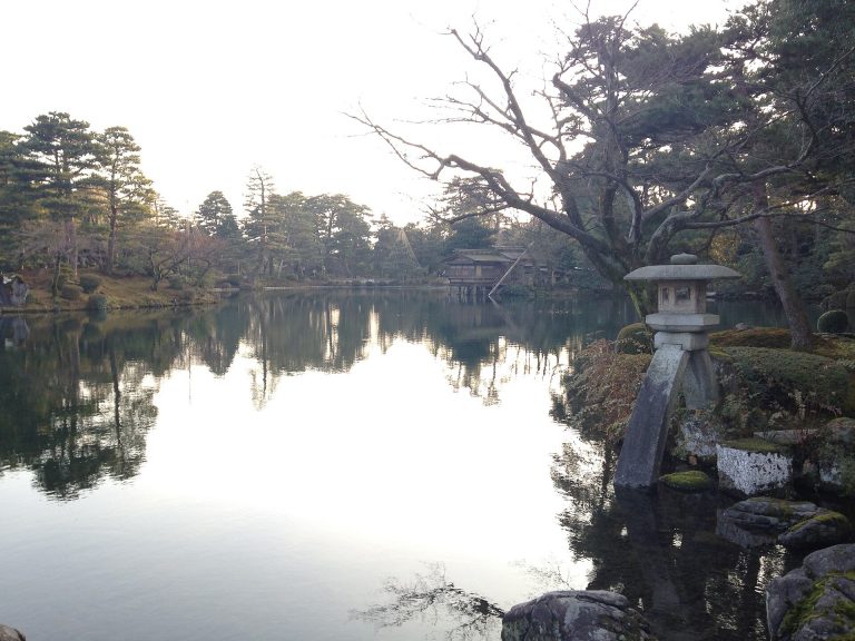 兼六園の霞ヶ池のほとりに立つ徽軫灯籠と、対岸の雪吊りが施された松