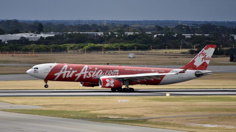 滑走路を滑走するエアアジアXのエアバスA330(9M-XXQ)。赤い胴体に白文字のAirAsia.com