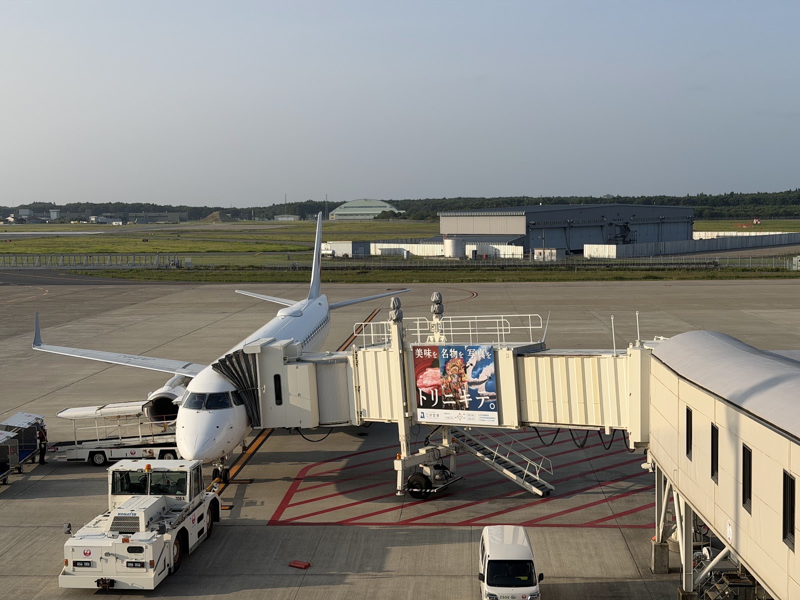 三沢・八戸2泊3日・1人旅|どこかにマイルで弾丸旅行 3 三沢空港 送迎デッキから見たボーディングブリッジのJALの小型機と格納庫(2026-09-05撮影)