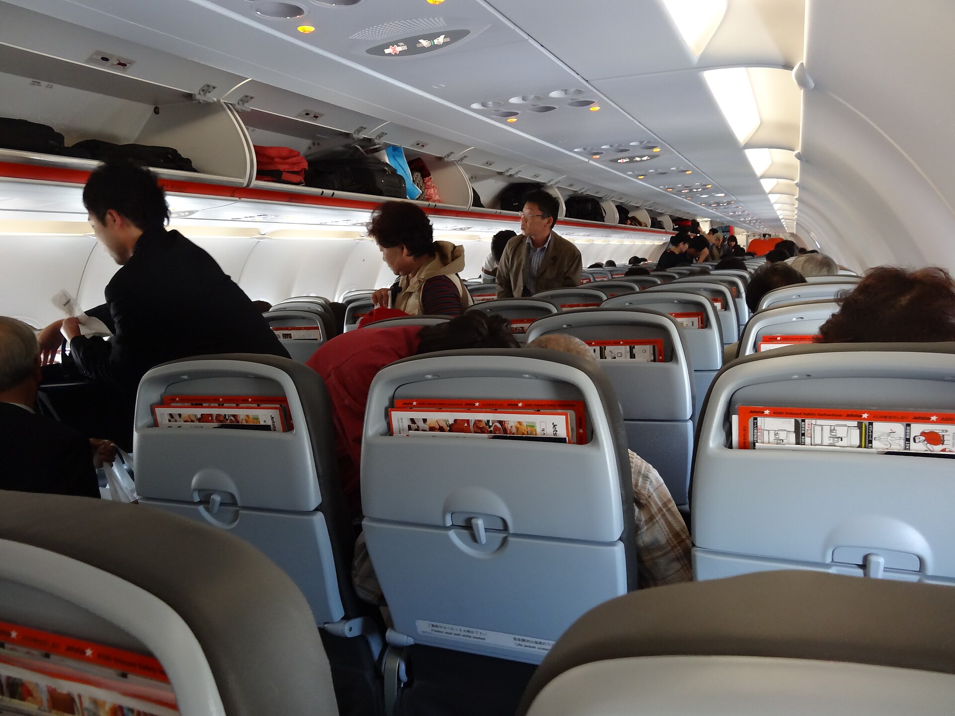 LCC機内持ち込み7kgの収め方|4社のサイズ規定と超過時の料金 1 ジェットスター・ジャパンのA320の機内。開いた頭上の収納棚に手荷物が並ぶ