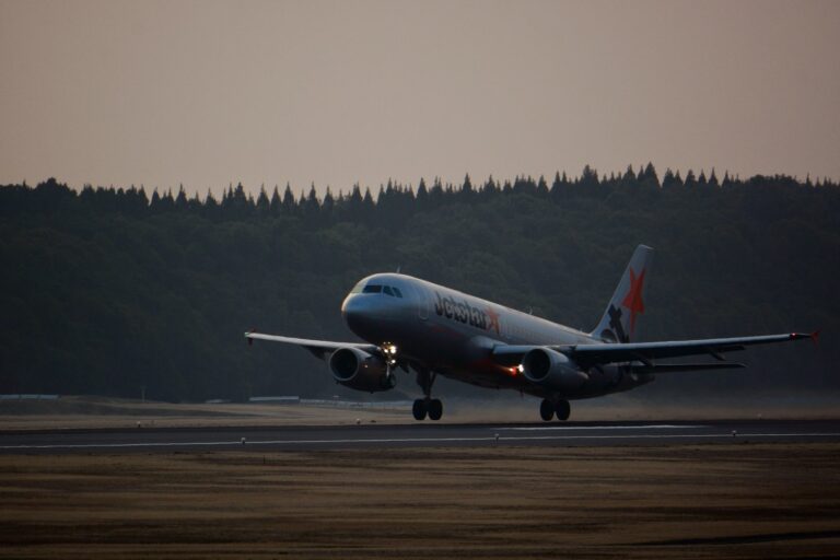 夕暮れの成田空港の滑走路から離陸するジェットスター・ジャパンのエアバスA320
